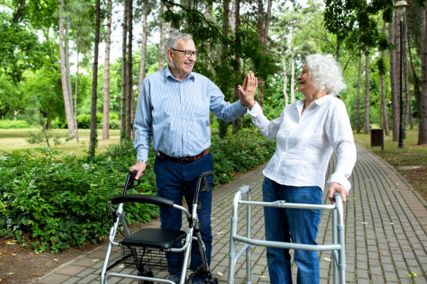 istock Senior couple in high five mode during a walk with helpers 1286480552