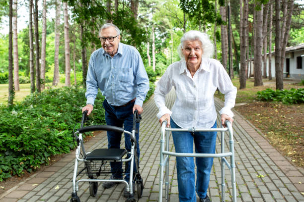 istock Elderly couple in the park strolling with walkers 1286480871