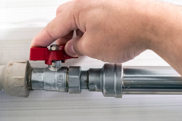 istock Man's hand closing water valve with red handle. Ball valve used in plumbing and heating systems. plumbing fittings. 1286481086