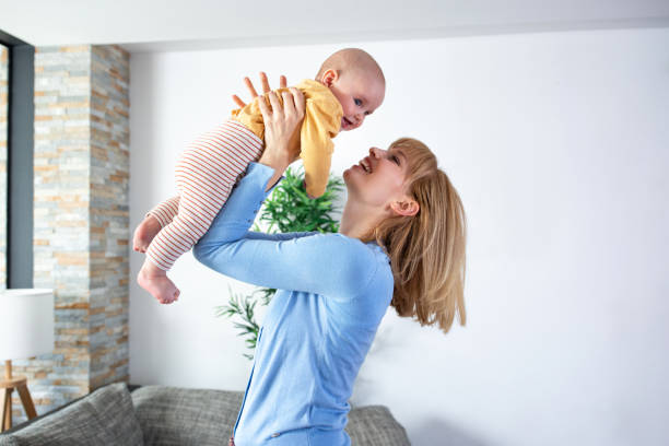 istock Loving mother holding her child while standing and playing tossing with him 1286482814