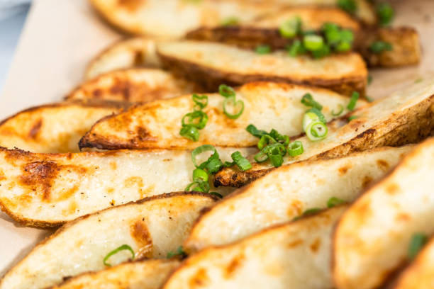 istock Freshly baked potato wedges with spices on a white serving tray. 1286482862