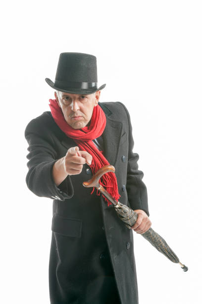 istock Elegant man in coat and top hat gesturing with umbrella 1286483668