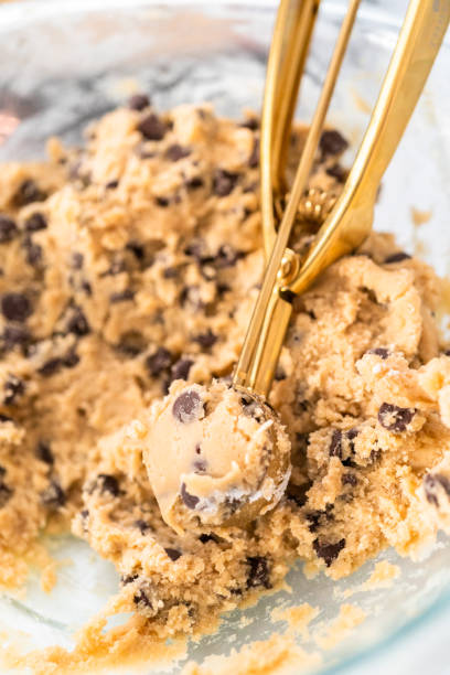 istock Homemade cookie dough with chocolate chips in a glass mixing bowl. 1286484003