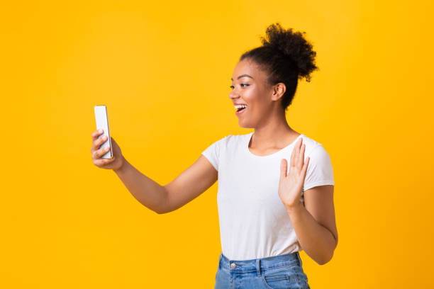 istock Happy black lady making video call using mobile phone 1286485534