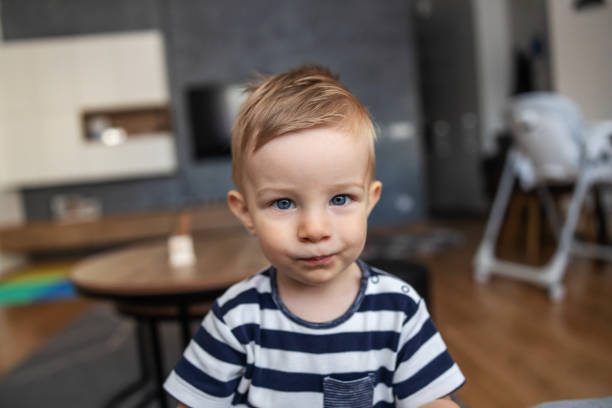 istock Cute little blond boy with beautiful blue eyes looking at camera with unsatisfied face. 1286485640