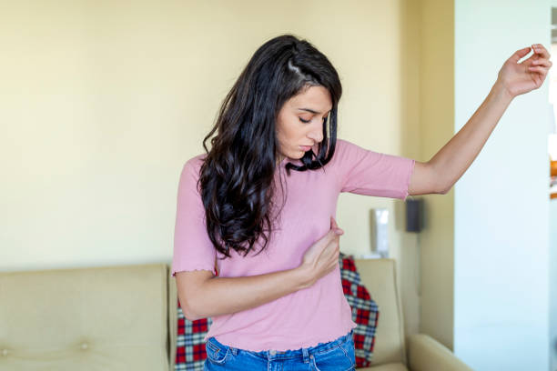 Young Woman with a pain in the breasts. portrait of an attractive young woman holding her chest A beautiful young woman is suffering from pain in the breast. She is touching her body to check that everything is ok. BSE or Breast Self-Exam. Guidelines to check for breast cancer. breast stock pictures, royalty-free photos & images