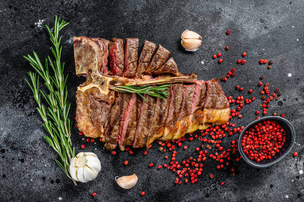 istock Grilled T-bone steak. Cooked tbone beef. Black background. Top view 1286487287