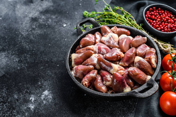 istock Raw chicken hearts in a pan. Organic offal. Black background. Top view. Copy space 1286489193