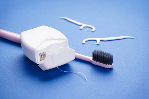 istock Toothbrush and dental floss on a blue background, close-up 1286489292