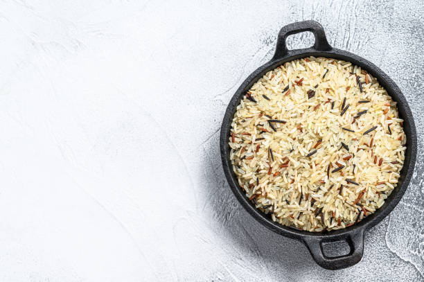 istock Mix rice in a cast-iron pan. White background. Top view. Copy space 1286489461