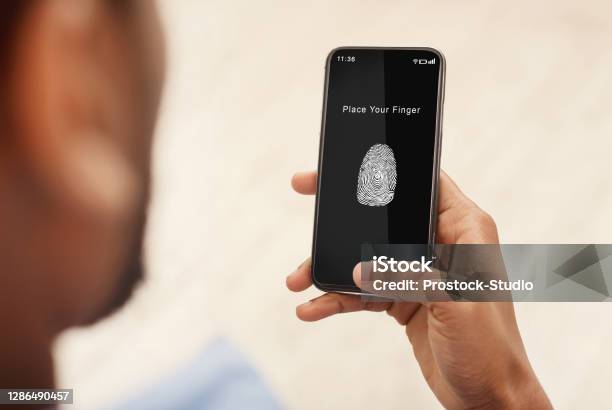 Man Holding Phone With Fingerprint Scanning App Stock Photo - Download Image Now - Fingerprint, Mobile Phone, Men