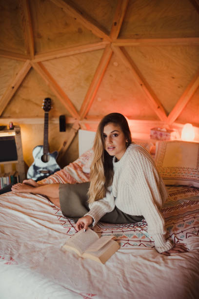 istock Young woman reading a book on a bed 1286490698