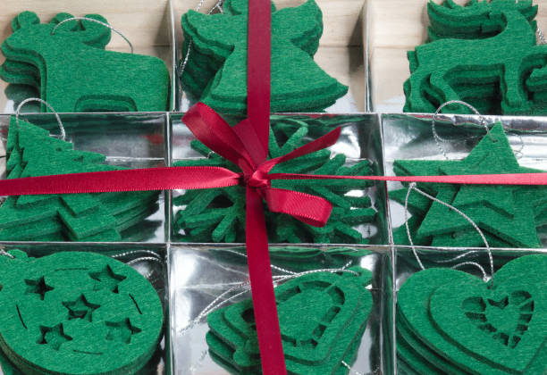 Christmas holidays background with copy space for your text. Christmas, New year and Holidays concept. New year's frame with a gift box full of green felt toys they lie on a silver substrate - this is a Christmas tree, a ball, a star, an elk , a deer, a bell, a heart. marco de año nuevo con una caja de regalo llena de juguetes de fieltro verde que se encuentran sobre un sustrato de plata - este es un árbol de navidad, una bola, una estrella, un alce, un ciervo, una campana, un corazón. vacaciones de navidad fondo con