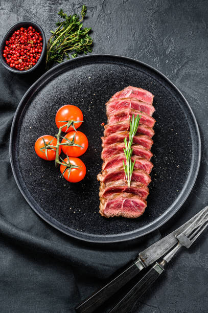 Sliced beef steak Top Blade, black Angus. Black background. Top view Sliced beef steak Top Blade, black Angus. Black background. Top view. blade roast stock pictures, royalty-free photos & images