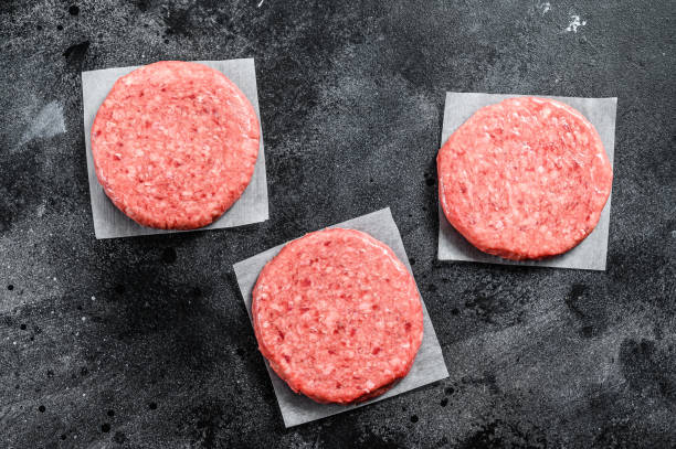 istock Raw ground meat cutlet, mince beef. Burger patties. Black background. Top view 1286492989