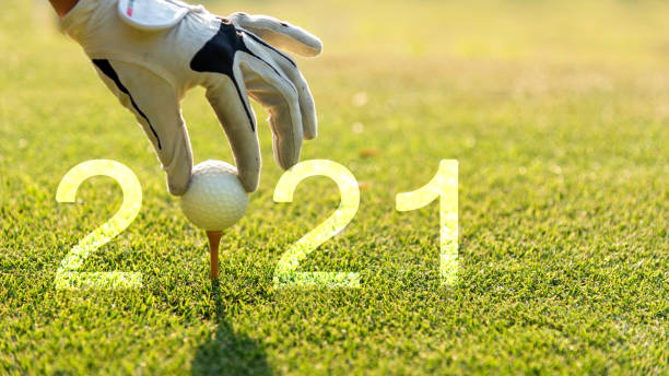 крупным планом руку гольфист женщина положить мяч для гольфа для счастливого нового года 2021 на зеленый гольф для новых здоровых.  копироват - condition optimal text healthy lifestyle стоковые фото и изображения