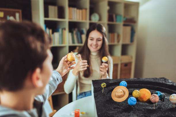 istock Happy school boy and girl making a solar system 1286493411