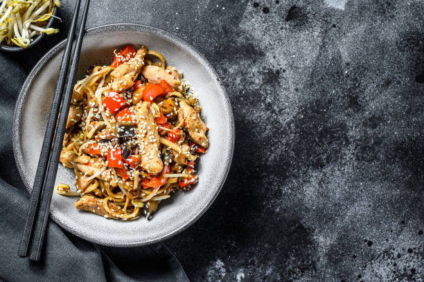 chicken stir-fry. wok udon noodles. traditional asian food. black background. top view. copy space - teriyaki broccoli carrot chicken imagens e fotografias de stock