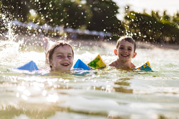 istock Little boys swimming in the ocean on a sunset 1286494385