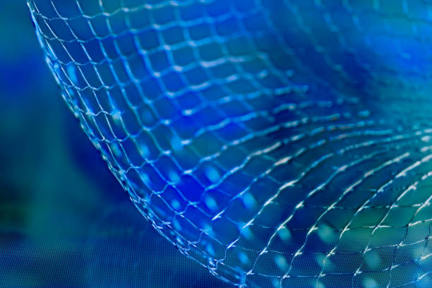 Close-up of dynamic wavy grid pattern on airy textile, plastic or wire mesh in surreal futuristic space. Science fiction. High tech