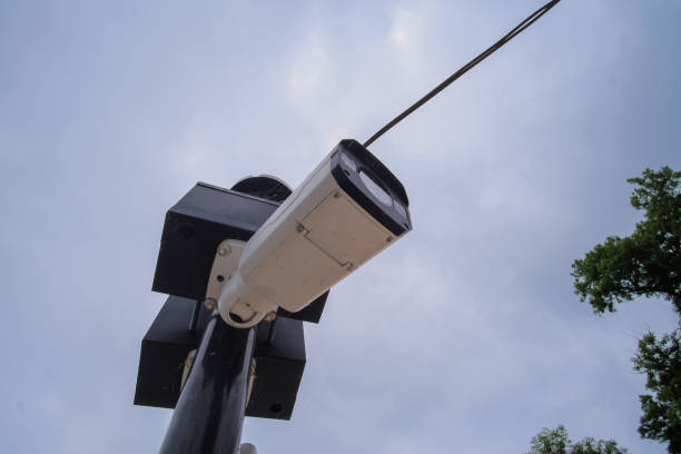 istock Security camera hanging among wire in guarded bridge with cloudy sky background. 1286495378