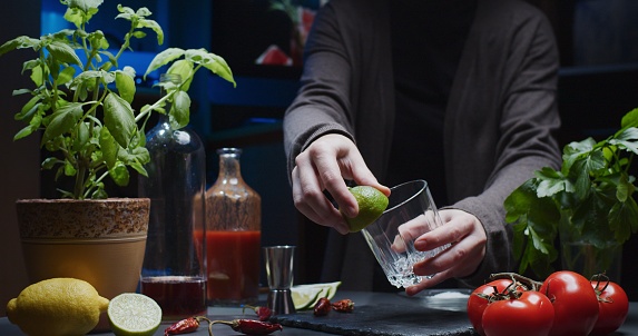 Unrecognisable person is making mocktail with tomato and lime juice