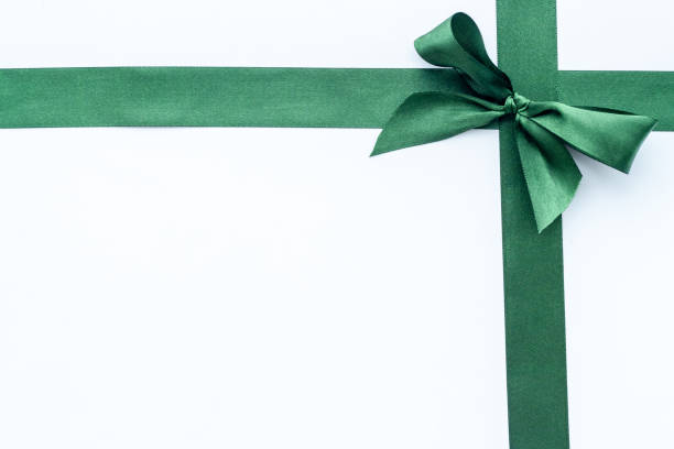 istock Festive green ribbon with bow isolated on white. Top view, copy space 1286498721