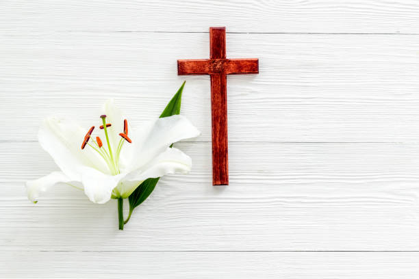 istock Lily funeral flower with cross. Condolence card with copy space 1286498936