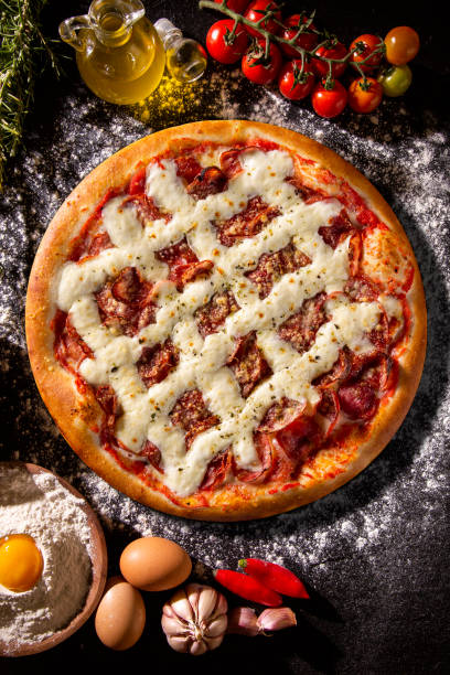 istock Pizza pepperoni with cream cheese on black concrete background. Top view, close up. Traditional Brazilian Pizza 1286500962