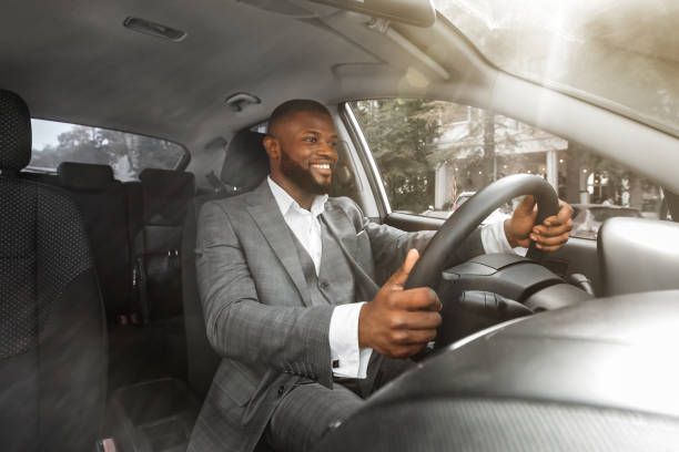 istock Positive african american businessman driving car, front panel shot 1286502310