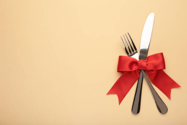 istock Fork and spoon with red ribbon on beige. Christmas setting 1286502436