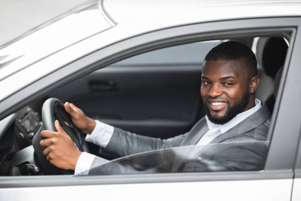 istock Side view of black man driver looking through car window 1286503390