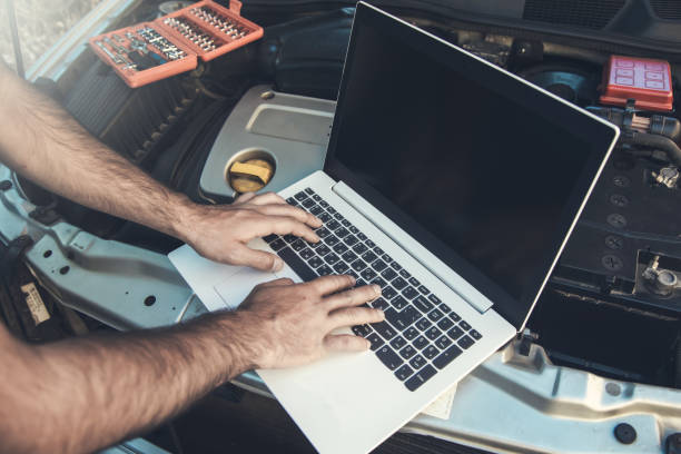 istock Professional car mechanic working in auto repair service using laptop 1286506940