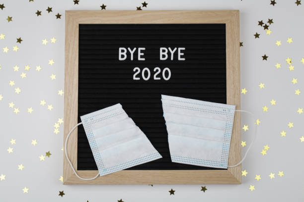 istock black letter board with text BYE BYE 2020 with cut mask on white background with small stars . Top view. New Year Christmas minimal background 1286511115