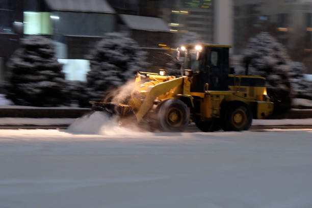 istock Wheel loader is removing snow at night during snowfall. Selective focus, blurred. Snow removing concept. 1286512121