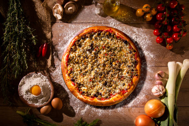 istock Various vegetables at wooden rustic background with copyspace on round pizza desk. Set of fresh vegetables. Egg, tomatoes, pepper, lettuce, onion, garlic, onion. Pizza ingredients. 1286517774