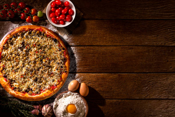 istock Various vegetables at wooden rustic background with copyspace on round pizza desk. Set of fresh vegetables. Egg, tomatoes, pepper, lettuce, onion, garlic, onion. Pizza ingredients. 1286518356