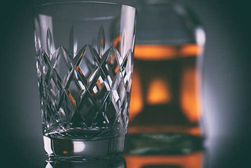 A crystal glass with a whisky bottle.