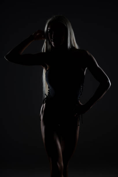 istock Silueta Young Female Posing Over Black Background 1286518610