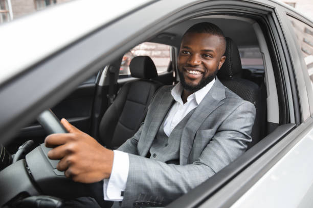 istock Smiling young black businessman driving luxury car 1286519360