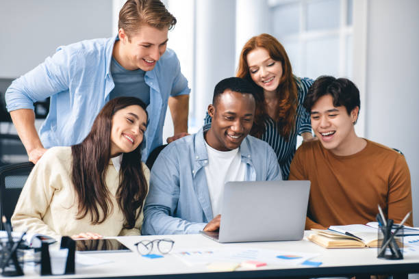 istock Group of international people using laptop and smiling 1286519457