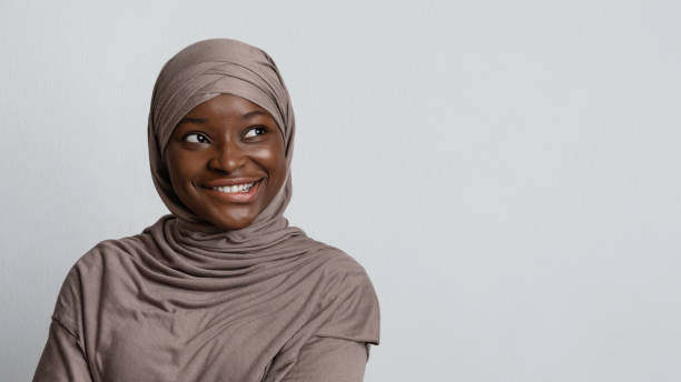 istock Curious black muslim woman looking at copy space, biting lip with excitement 1286519863