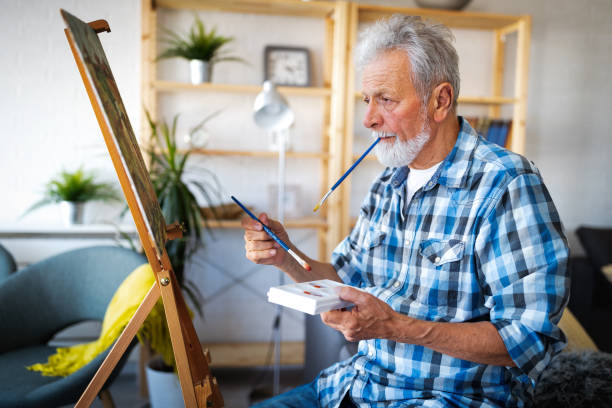 istock Happy retired man painting on canvas for fun at home 1286520200