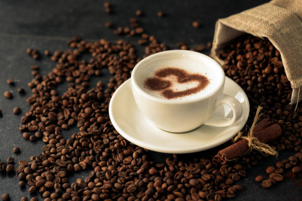 istock Tide of coffee beans advancing on a cup latte art 1286520454