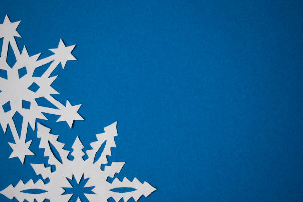 istock White paper handmade snowflakes on blue colored paper background 1286521230