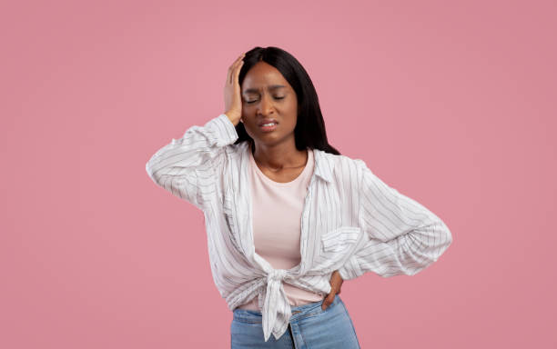 istock Overworked black woman suffering from headache on pink studio background, panorama 1286523543