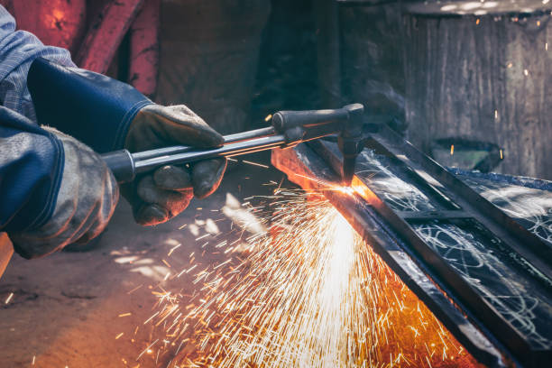 istock Close up hand heavy industrial worker is working on metal work factory process by Cutting sheet steel with gas cutting machine cutting thick steel in boilermakers workshop. 1286525707