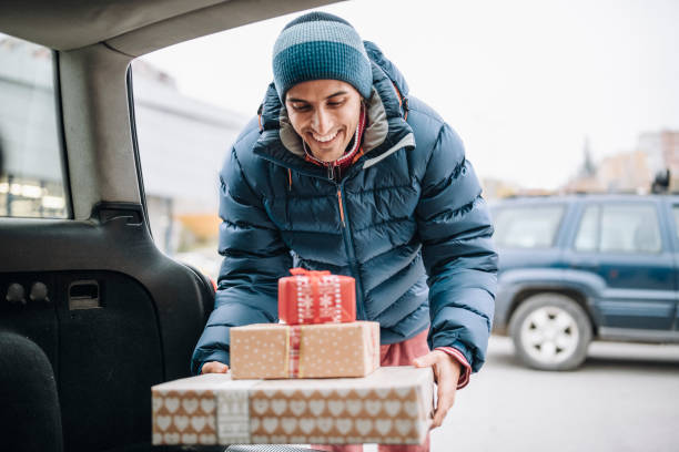 istock Adult man loading Christmas presents in car trunk. 1286526748