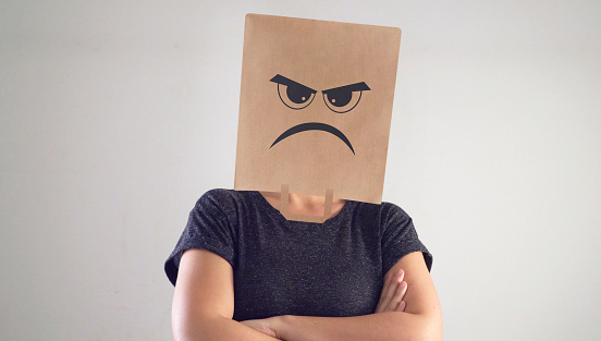 Woman with crumpled paper bag, with bored anger face. Angry woman.