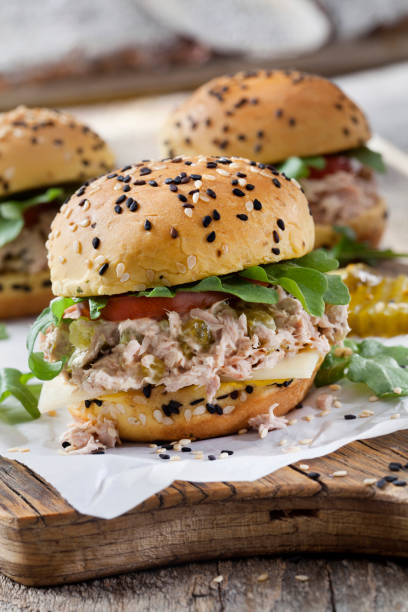 Creamy Tuna Sliders with Sweet Pickles, Swiss Cheese, Tomato and Arugula on Brioche Sesame Seed Buns